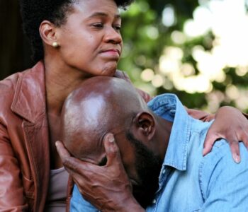Upset man, woman consoling partner